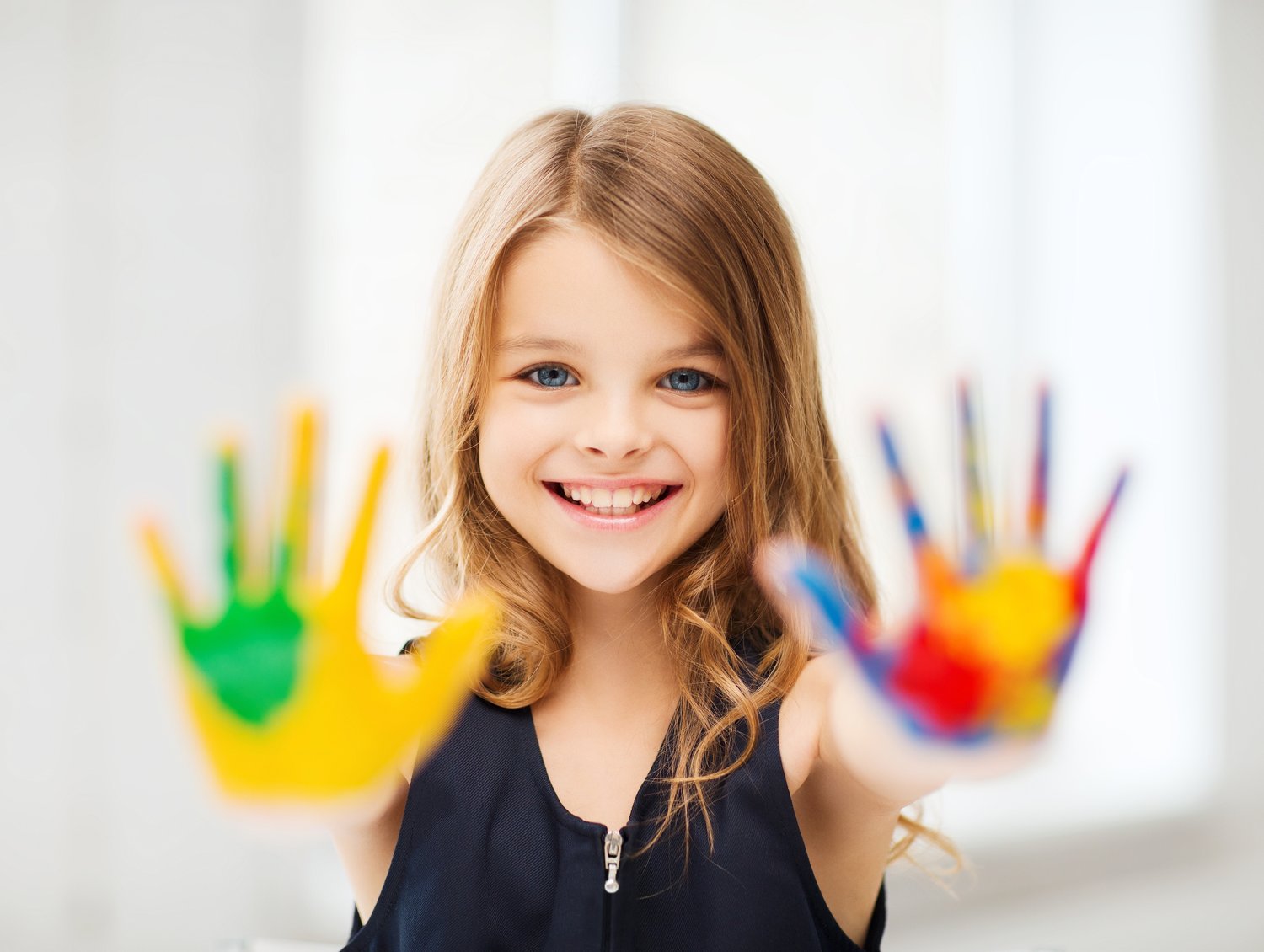 Happy girl with colorful painted hands